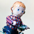 Boy on bycicle with dog tin toy